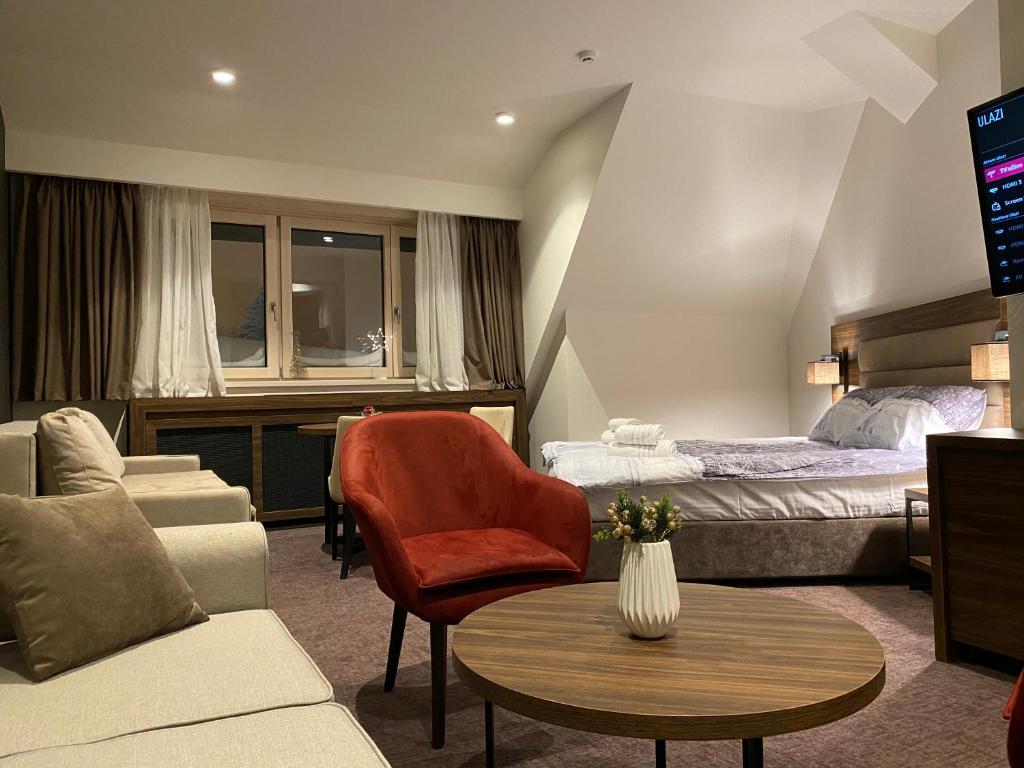 科帕奥尼克Teddy Apartman Kula Konaci的酒店客房配有床、沙发和桌子。