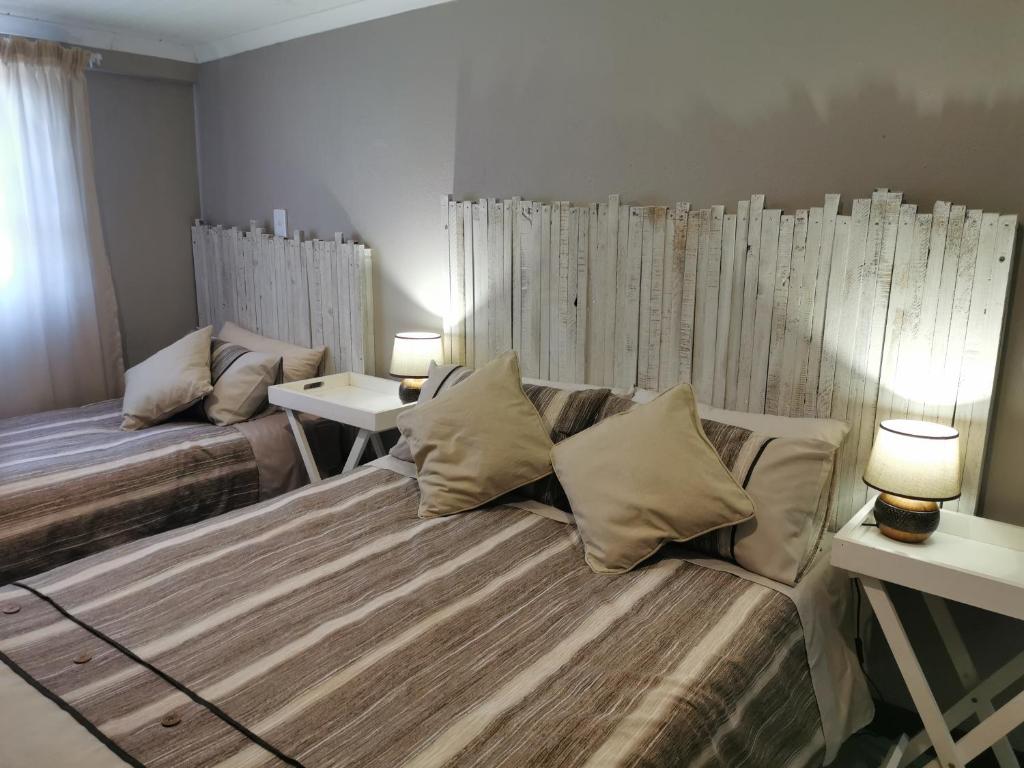 VredenburgKom Kuier Self-Cater的一间卧室设有两张床和两张带台灯的桌子。