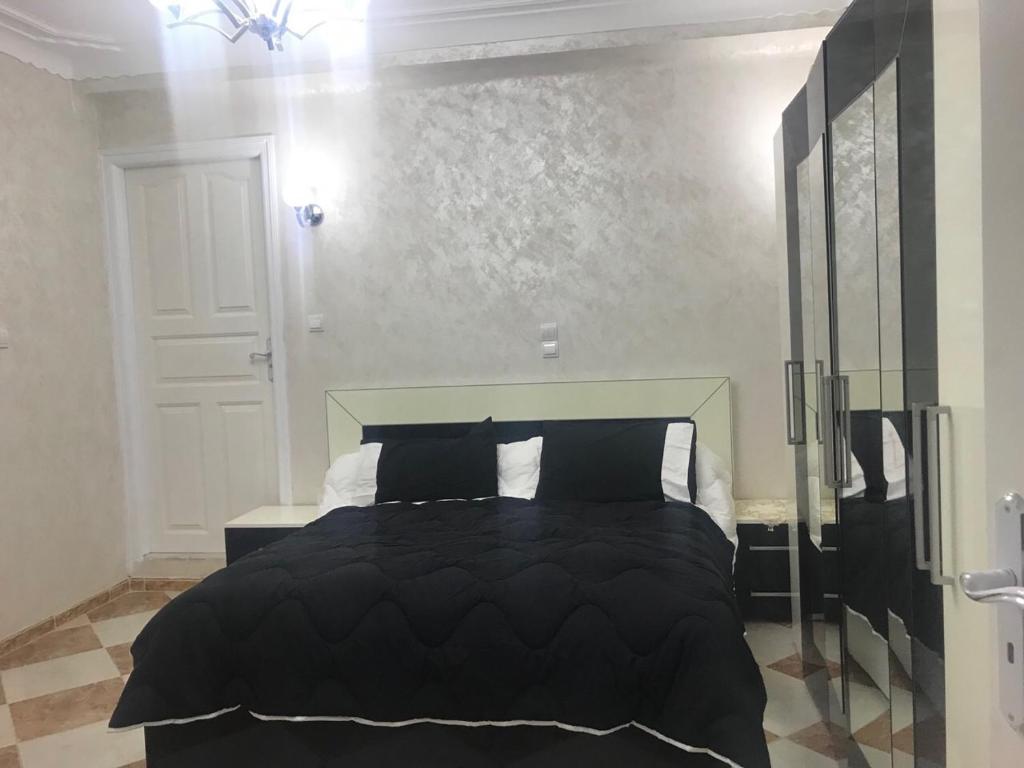 贝贾亚Super appartement de luxe T4 a la ville de Bejaia的一间卧室配有一张带黑色棉被的床
