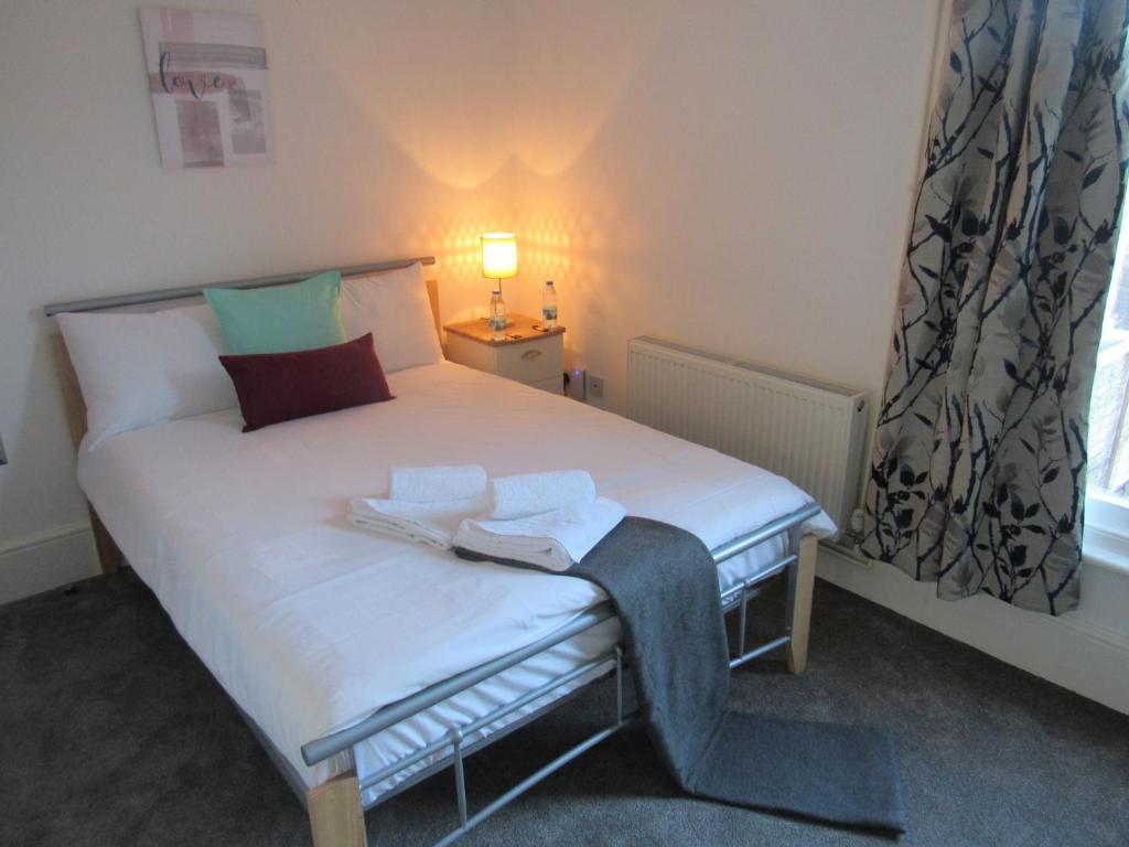 剑桥The Tas Suites - Tas Accommodations的一间小卧室,配有白色的床和窗户