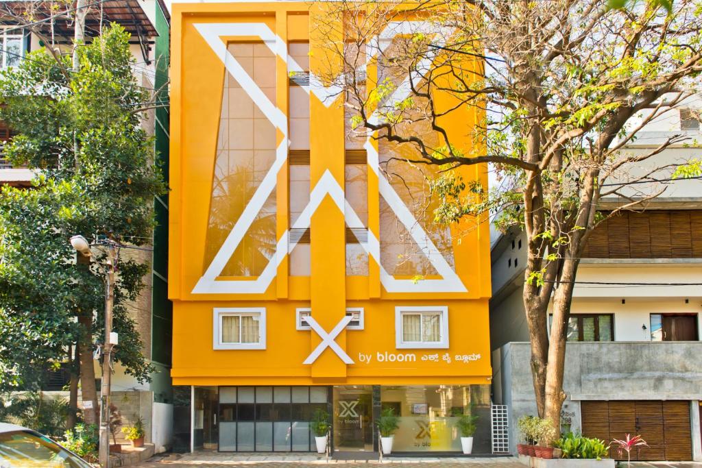 班加罗尔X by Bloom l Indiranagar的一座橙色的建筑,上面有大型的X标志