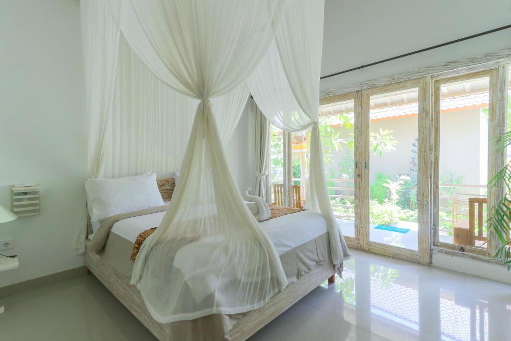 珀尼达岛Angels Bungalow Nusa Penida的一间卧室配有一张带蚊帐的床