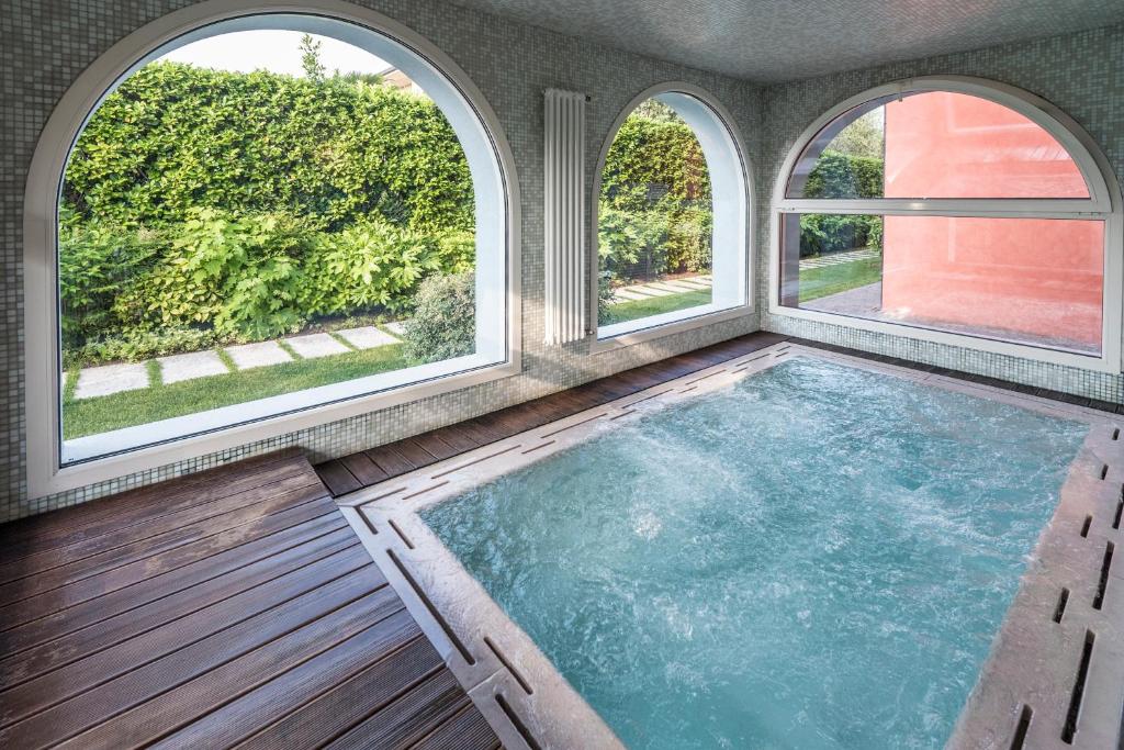 西尔米奥奈阿昌泉度假酒店的一座室内游泳池,里面设有三扇窗户