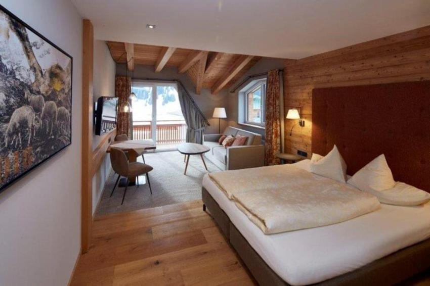 措布伦Alpenjuwel Rohnenspitze的一间卧室设有一张床和一间客厅。