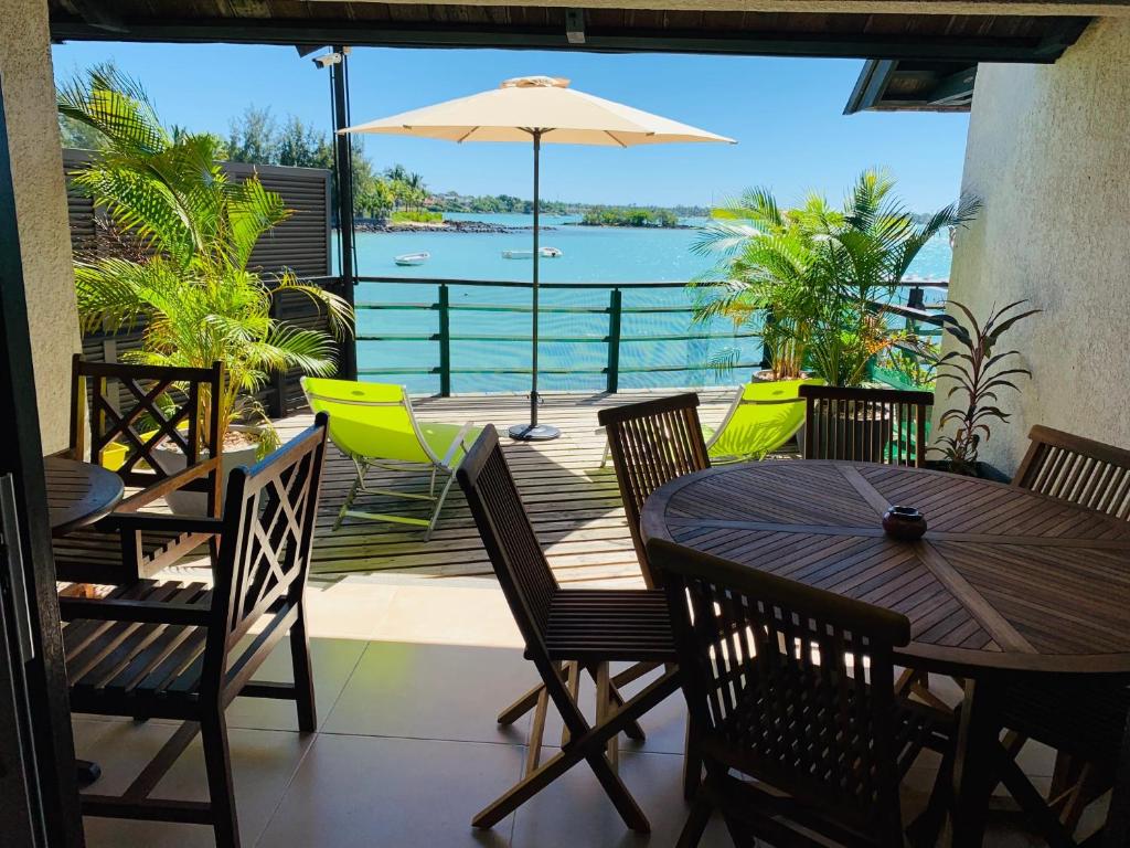 格兰贝伊appartement Grand Baie île Maurice的一个带桌椅的庭院,享有水景