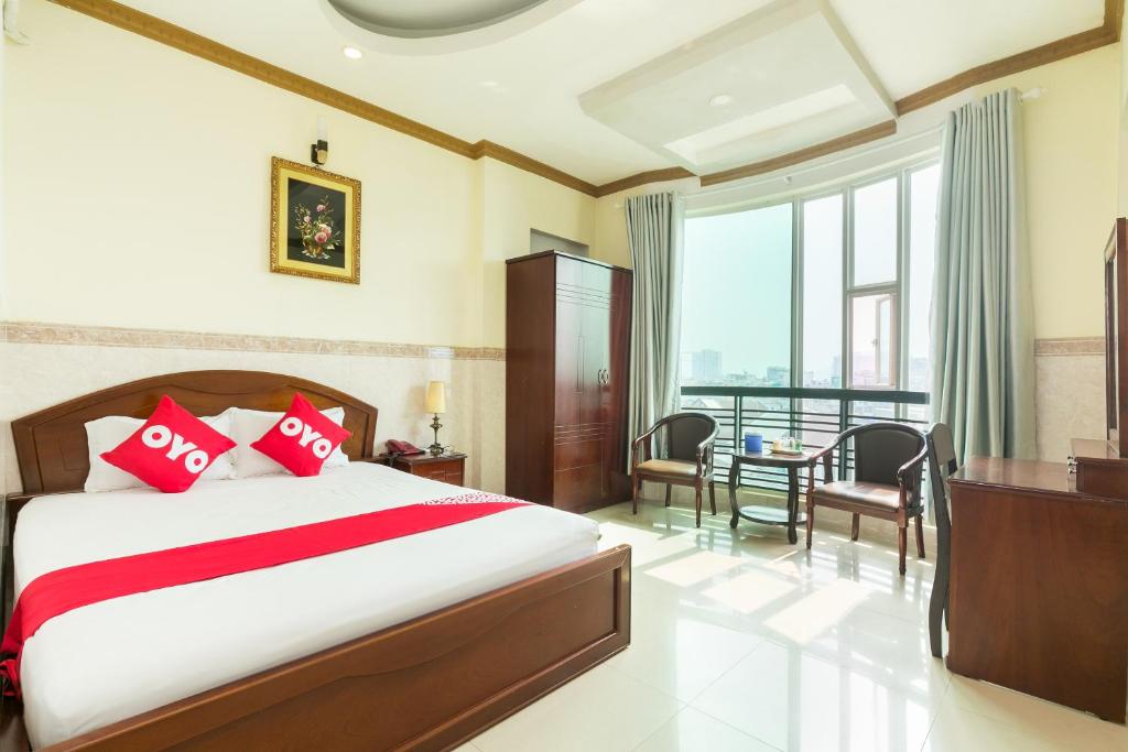 胡志明市NGAN HA Hotel的一间卧室配有一张带红色枕头的大床