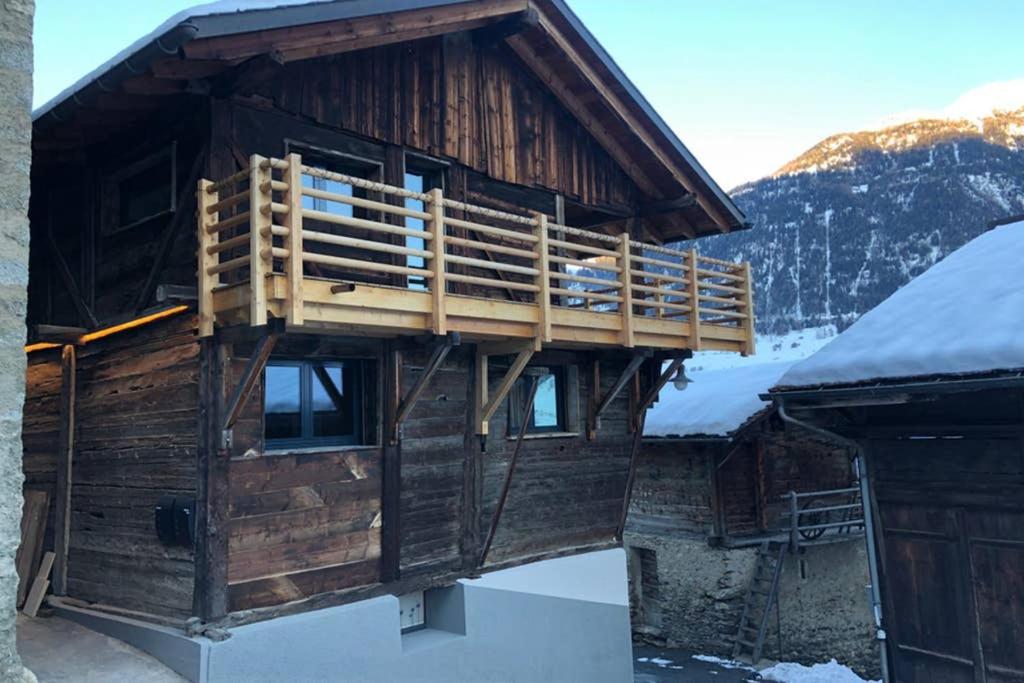 奥西耶尔Grand appartement avec terrasse à Chez-Les-Reuses的一座大型的木制建筑,屋顶上积雪