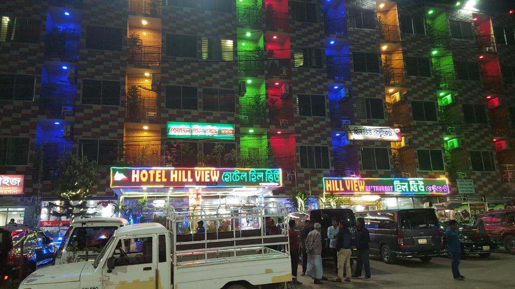 BāndarbanHotel Hill View的一群人晚上站在一座大楼前