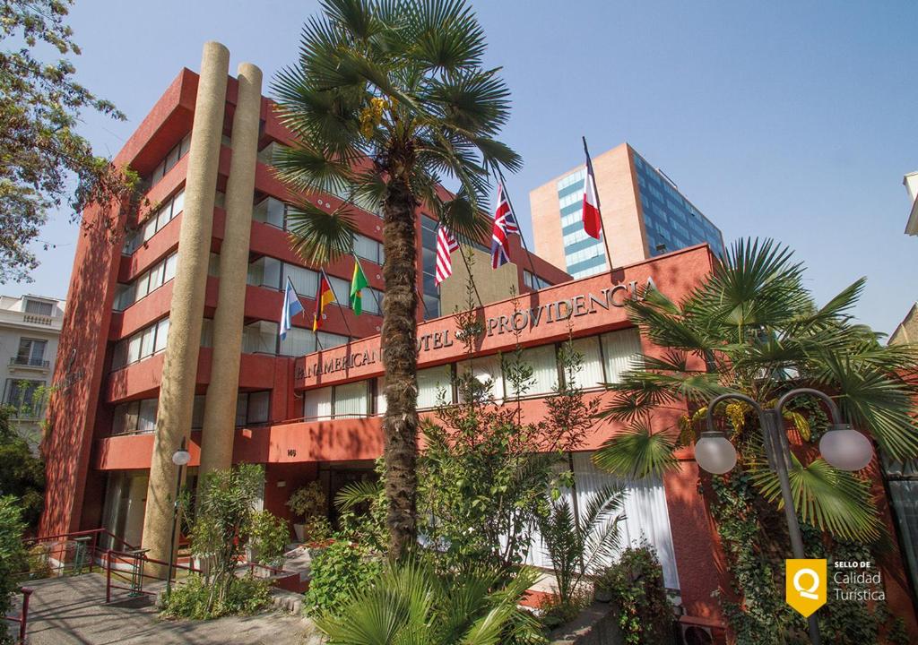 圣地亚哥帕纳美丽嘉纳普罗维登西亚酒店的前面有棕榈树的建筑