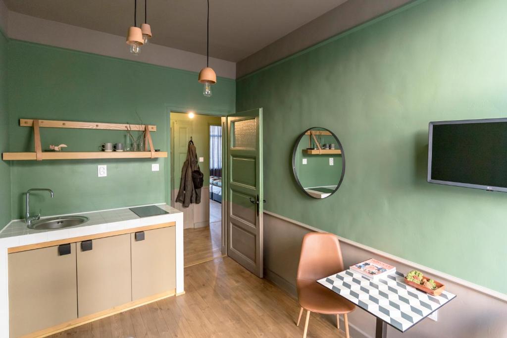 普罗夫迪夫Beautiful best location apartment Green Mouse的厨房设有绿色的墙壁、水槽和镜子