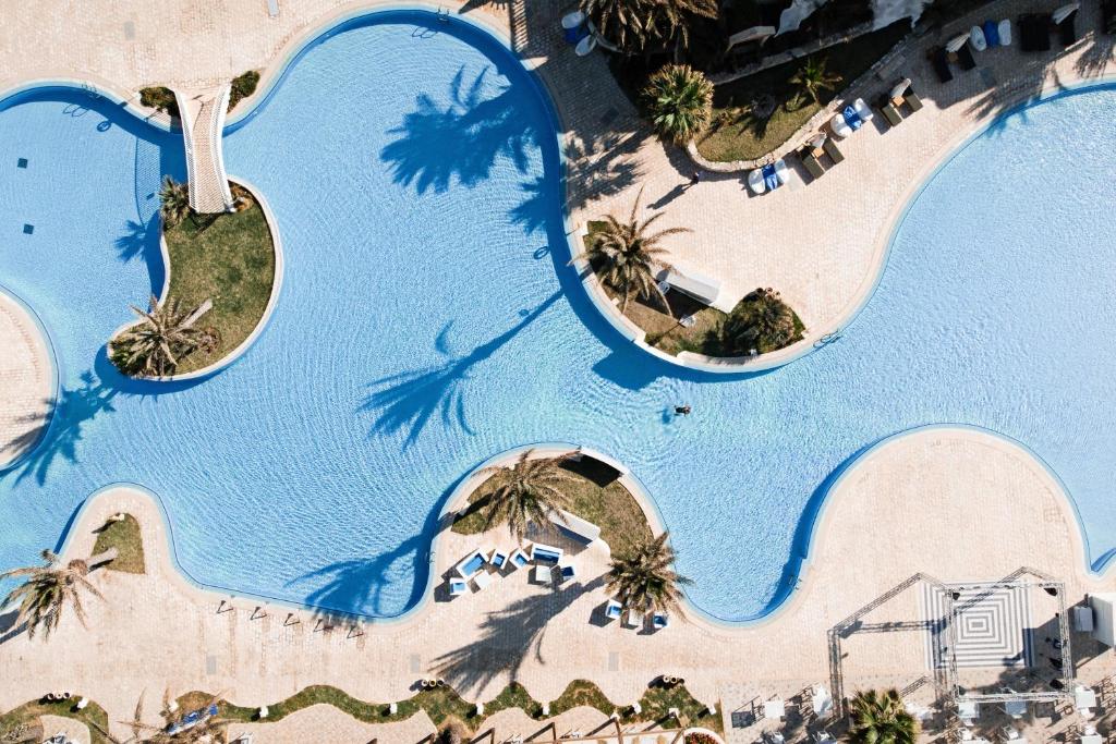 米多恩ROBINSON DJERBA BAHIYA - All Inclusive的享有棕榈树度假村游泳池的顶部景致