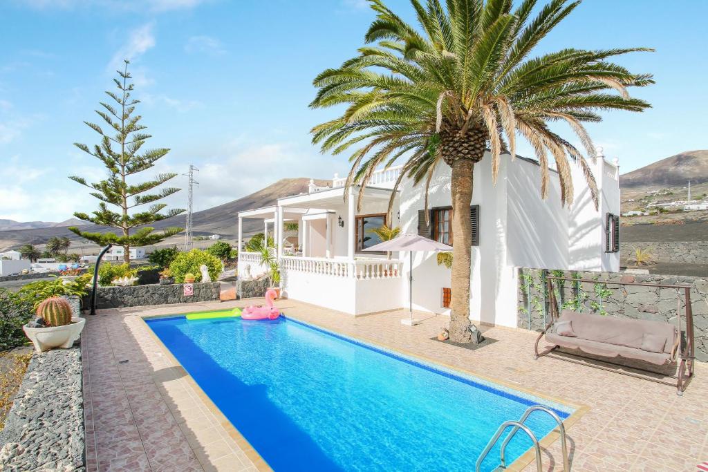 马赫Casa Salinoco的一座别墅,设有游泳池和棕榈树
