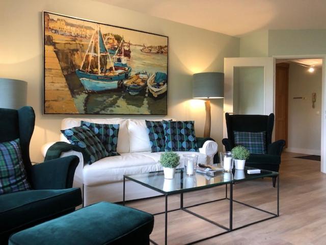 因斯布鲁克Luxury Apartment Axams的客厅配有白色沙发和小船绘画