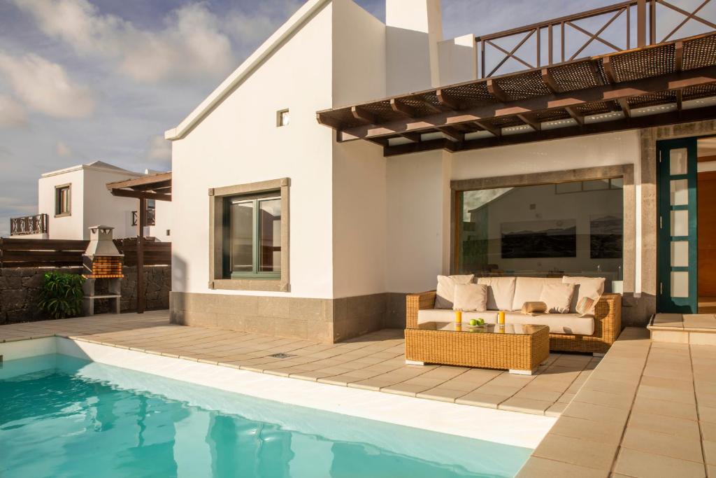 普拉亚布兰卡Playa Blanca Beach Mate的一座带游泳池和房子的别墅