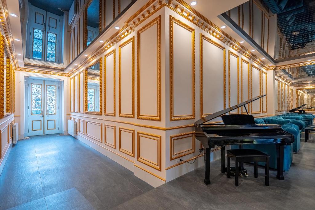 第比利斯5 STAR APART HOTEL的一间配有沙发的房间里,配有钢琴