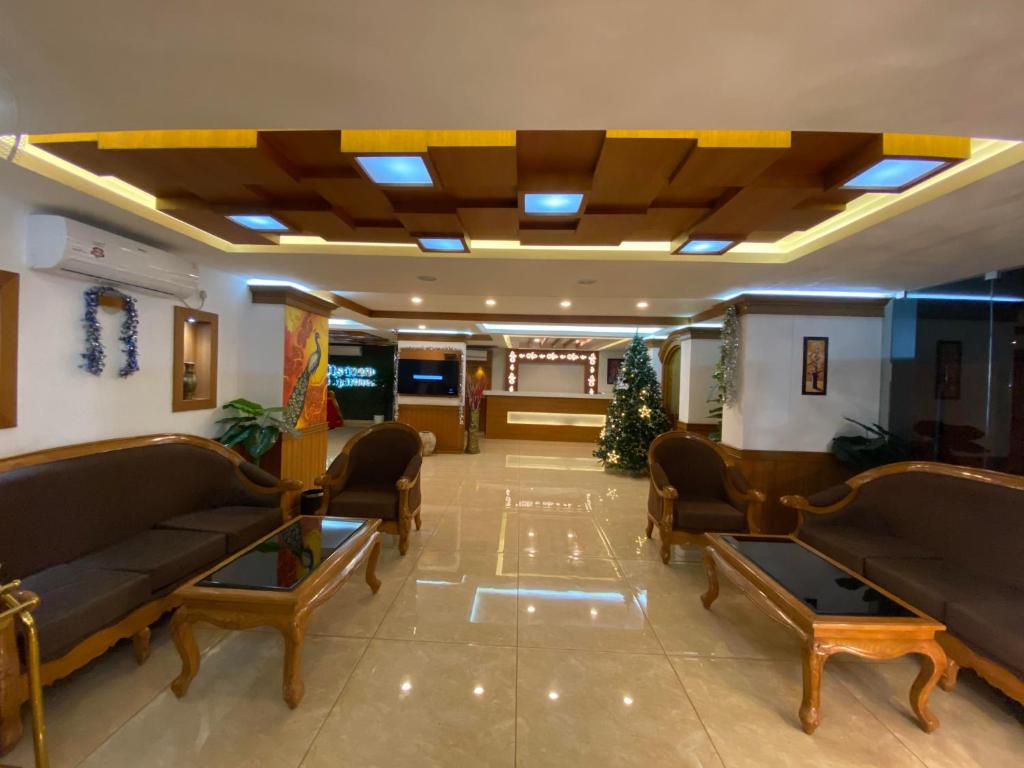 古鲁瓦尤尔Utsavam Hotel Apartments的大厅,在大楼里设有沙发和桌子