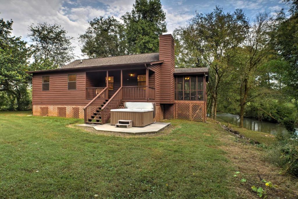 OoltewahCreekfront Cabin Near Chattanooga with Hot Tub!的木屋设有门廊和庭院