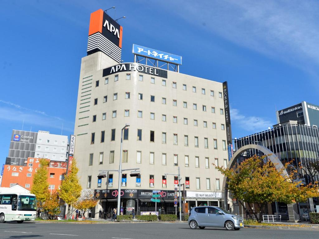 丰桥市APA Hotel Toyohashi-Ekimae的停车场停在大楼前