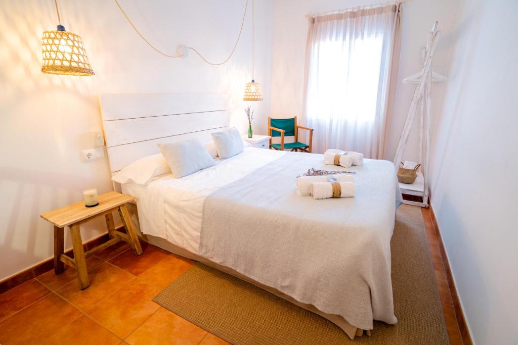 休达德亚Hostal Sa Posada Set Cales的卧室配有带毛巾的大型白色床