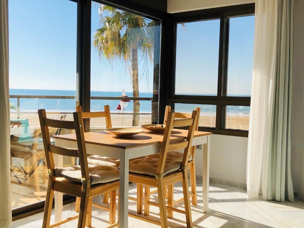 加的斯Victoria Beach Sunset Lounge的享有海景的餐桌和椅子