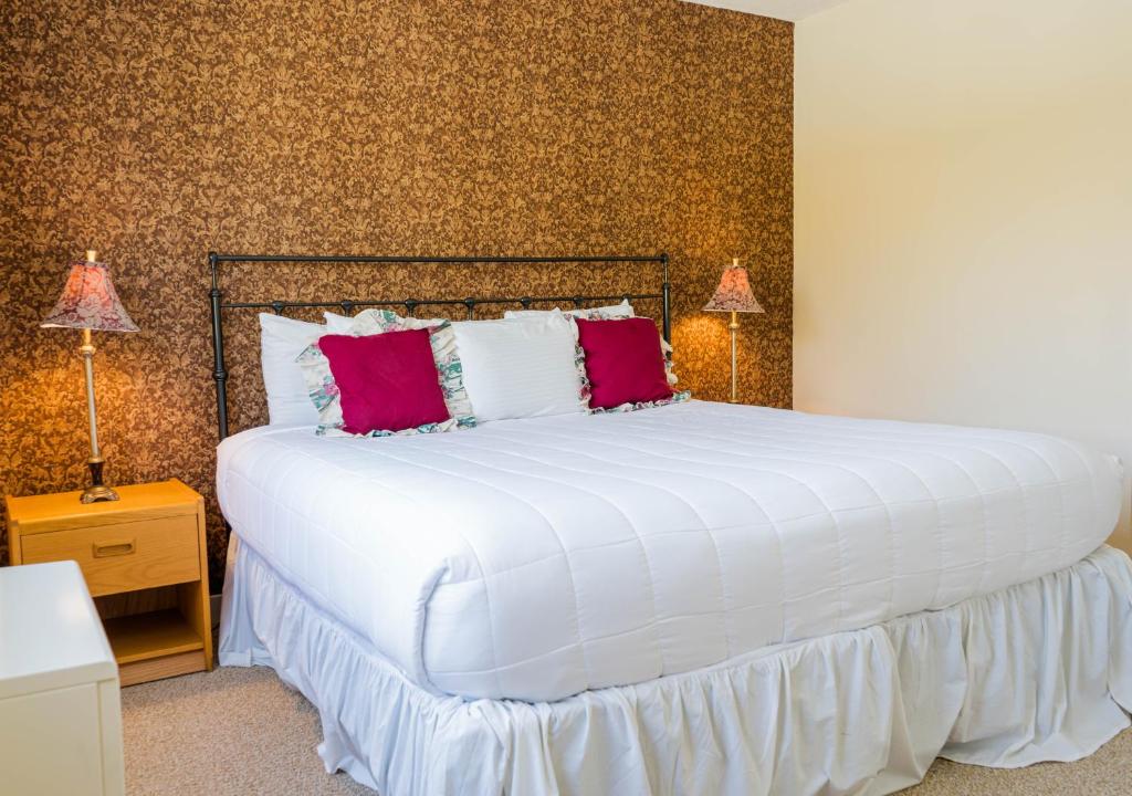 Stratton MountainVantage Point Villas at Stratton Mountain Resort的卧室配有带红色枕头的大型白色床
