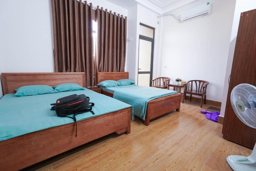 北宁Motel Xuân Hòa的一间卧室配有两张床,床上备有一个背包