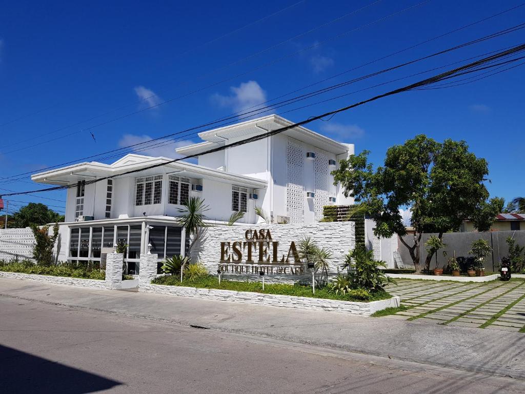 CalapanCasa Estela Boutique Hotel & Cafe的前面有标志的白色房子