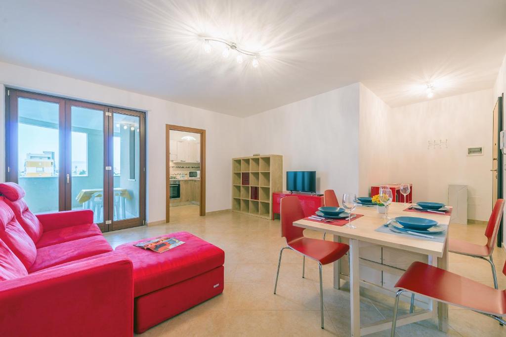 莱切GoodStay Archimede Apartment的客厅配有红色的沙发和桌子