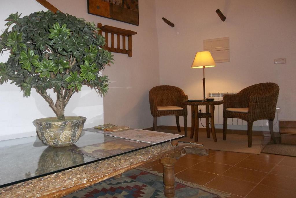 Las Cuevas de CañartCasa Rural La Buhardilla的客厅配有桌子和盆栽树