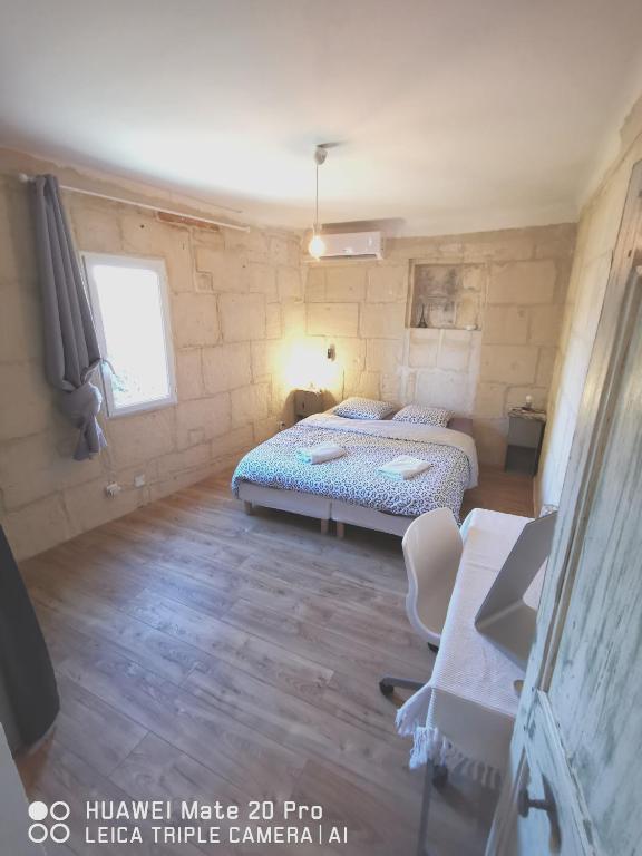 丰维耶Charmante maison en Provence的一间卧室配有两张床、一张桌子和一张书桌