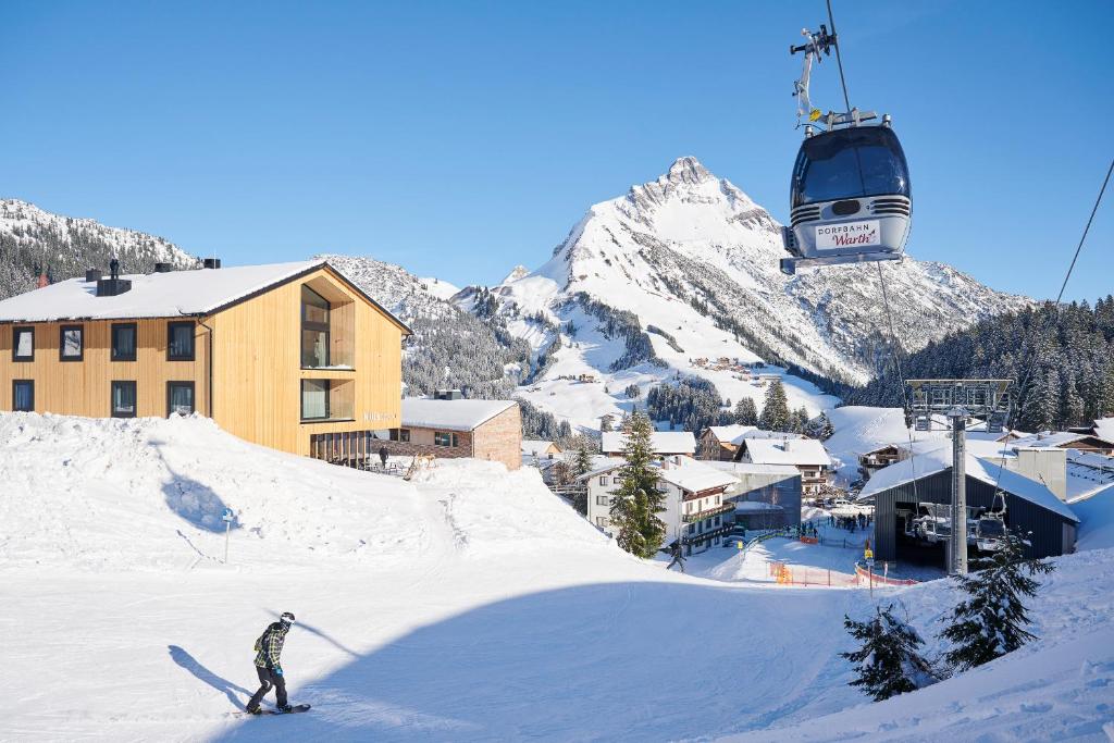 沃瑟姆阿尔伯格Warth52-W52 Apartments的滑雪者在滑雪缆车附近滑雪