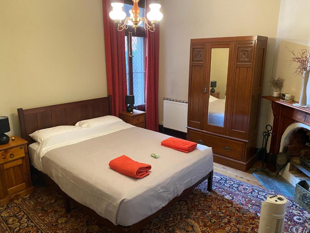亚斯Yass Central Bed & Breakfast的一间卧室配有一张带两个红色毛巾的床