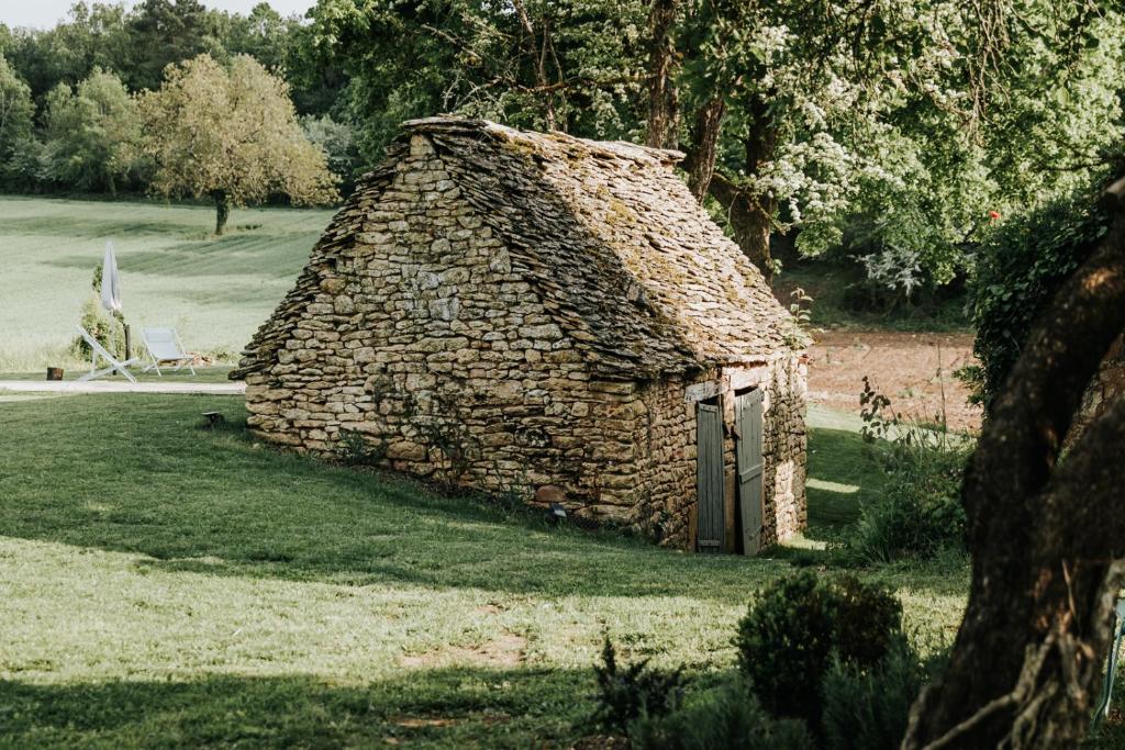 Saint-GenièsMaison d'hôtes Bel Estiu的草场上的一块小石头建筑