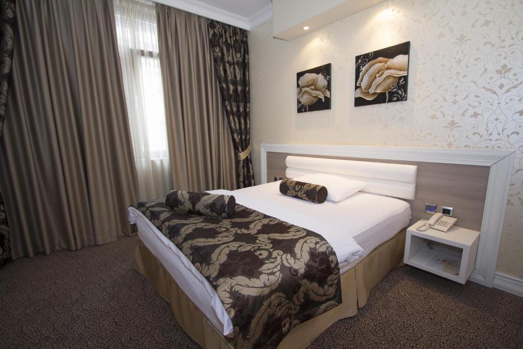 巴尼亚卢卡塔利亚酒店的一间酒店客房,配有一张床和一部电话
