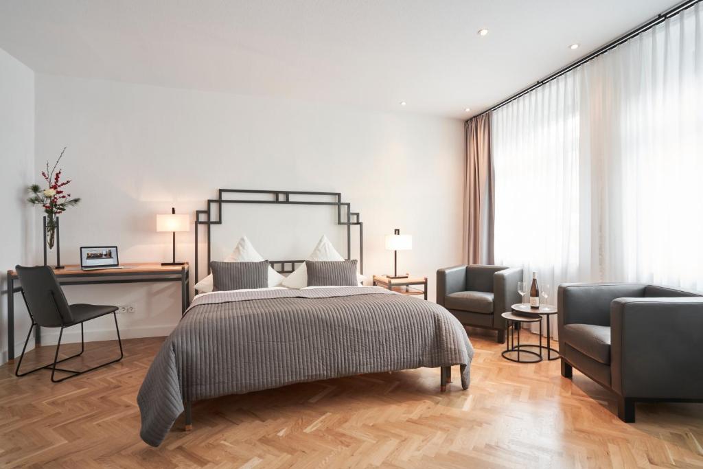 施派尔Hotel Goldener Engel的一间卧室配有一张床和两把椅子
