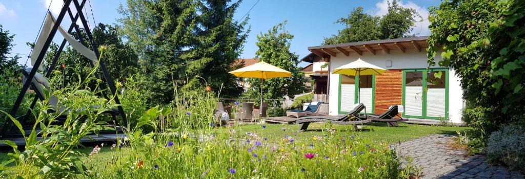 博登迈斯BIO Appartement Resort的花园设有两把椅子、一张桌子和黄色遮阳伞