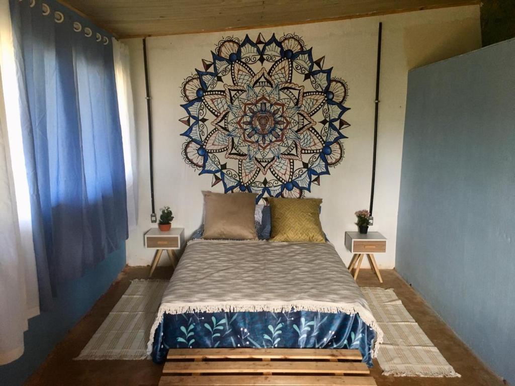 戈亚斯州上帕莱索Vila da Mata - Bambu House的卧室配有一张挂在墙上的曼陀罗床