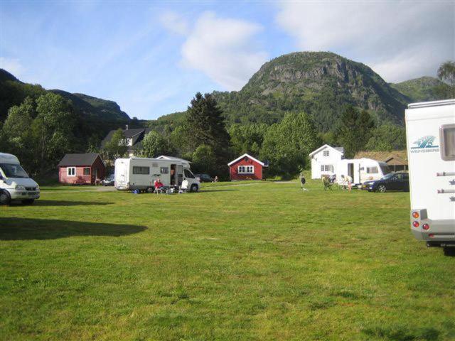 勒尔达尔Seim Camping - Røldal的一片有房子的田野和山地