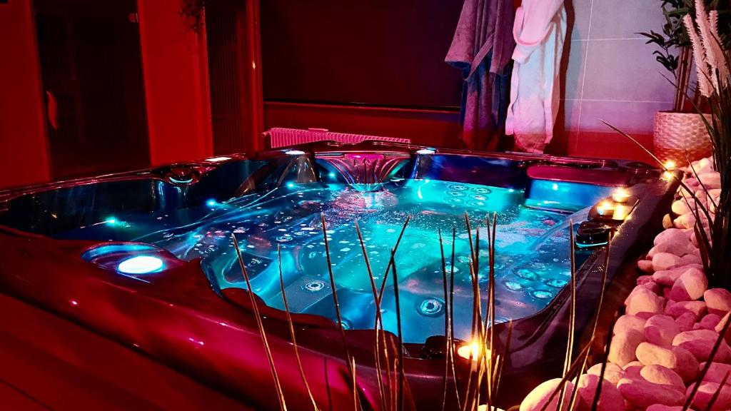 埃夫勒Suite avec Jacuzzi et Sauna Privée的客房内的蓝光热水浴池