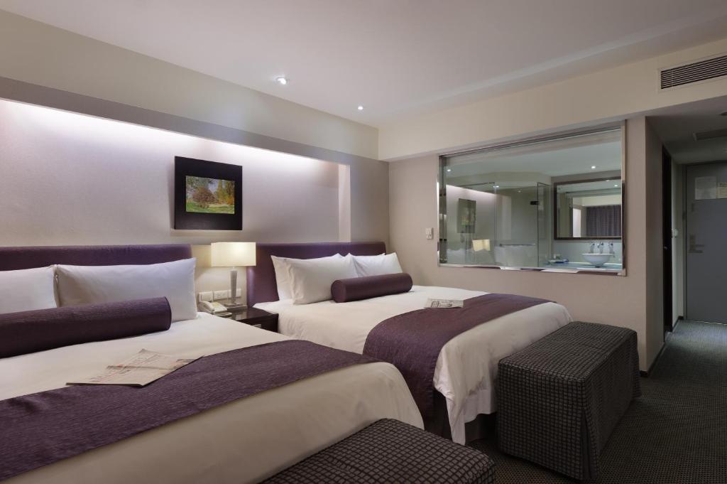 永和柯达大饭店永和店的酒店客房,设有两张床和镜子