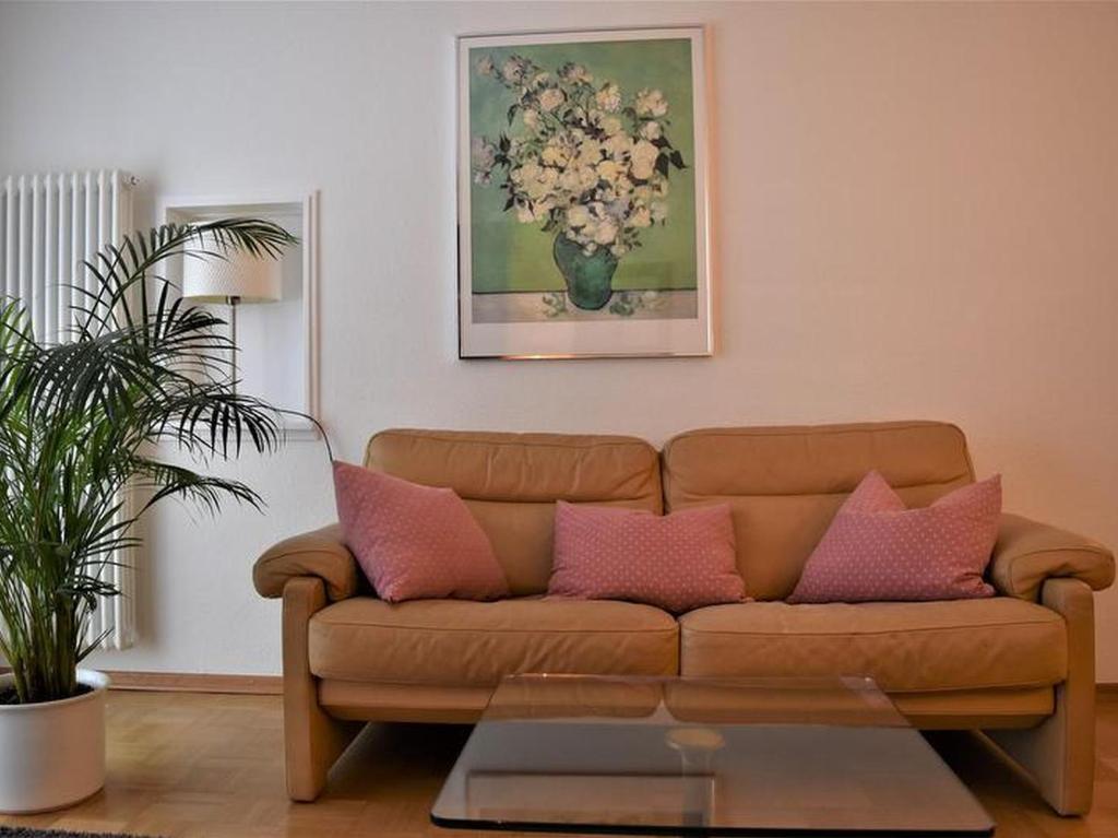 弗莱堡Ferienwohnung Sonja的客厅配有带粉红色枕头的棕色沙发