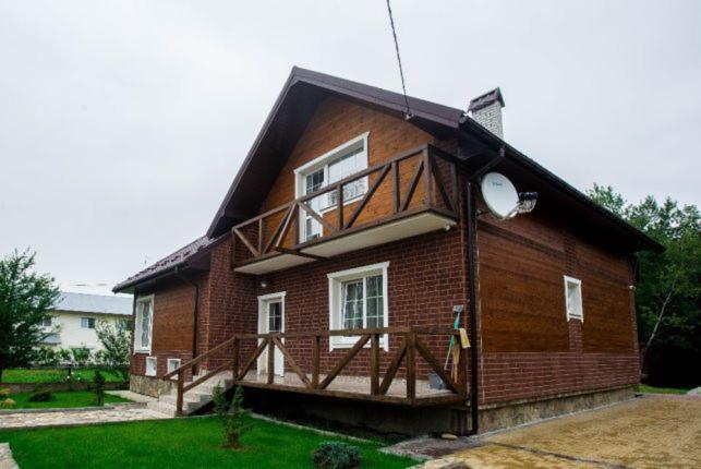莫申Садиба Вікторія的一座小砖房子,上面设有阳台
