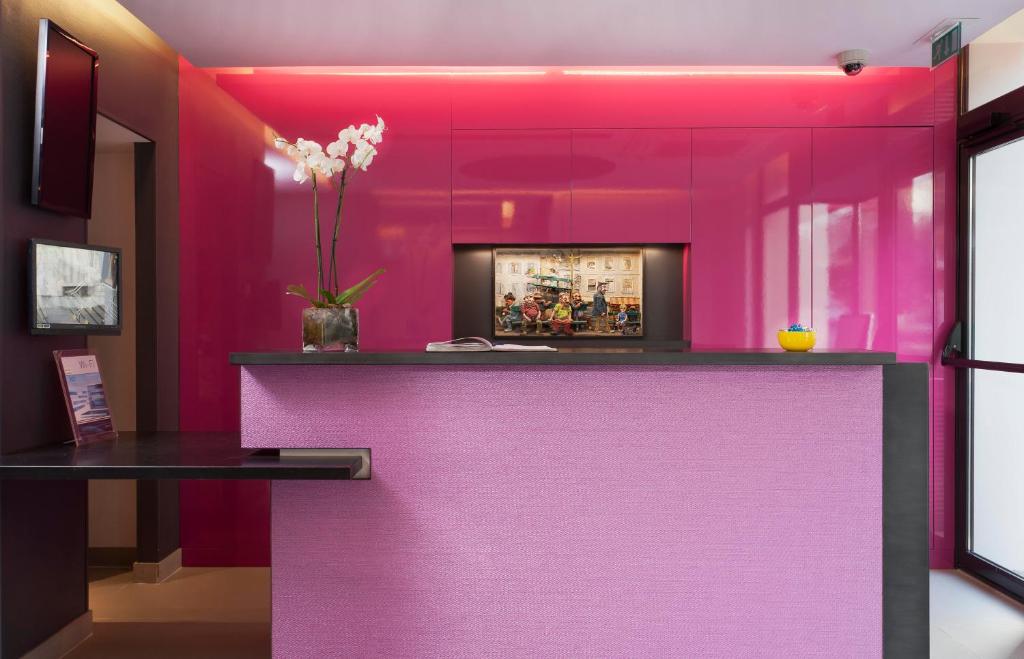 巴黎里贝特瑞典北车站酒店的一间有柜台的房间的粉红色墙壁