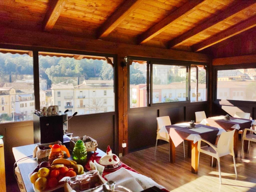 科森扎B&B L’antico Rudere的用餐室设有桌椅和窗户。