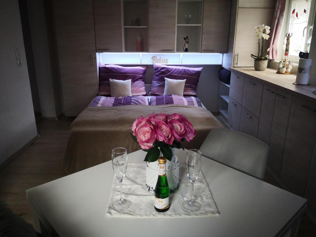 AltachRheintal Zentrum的一张桌子,上面放着一瓶葡萄酒和鲜花