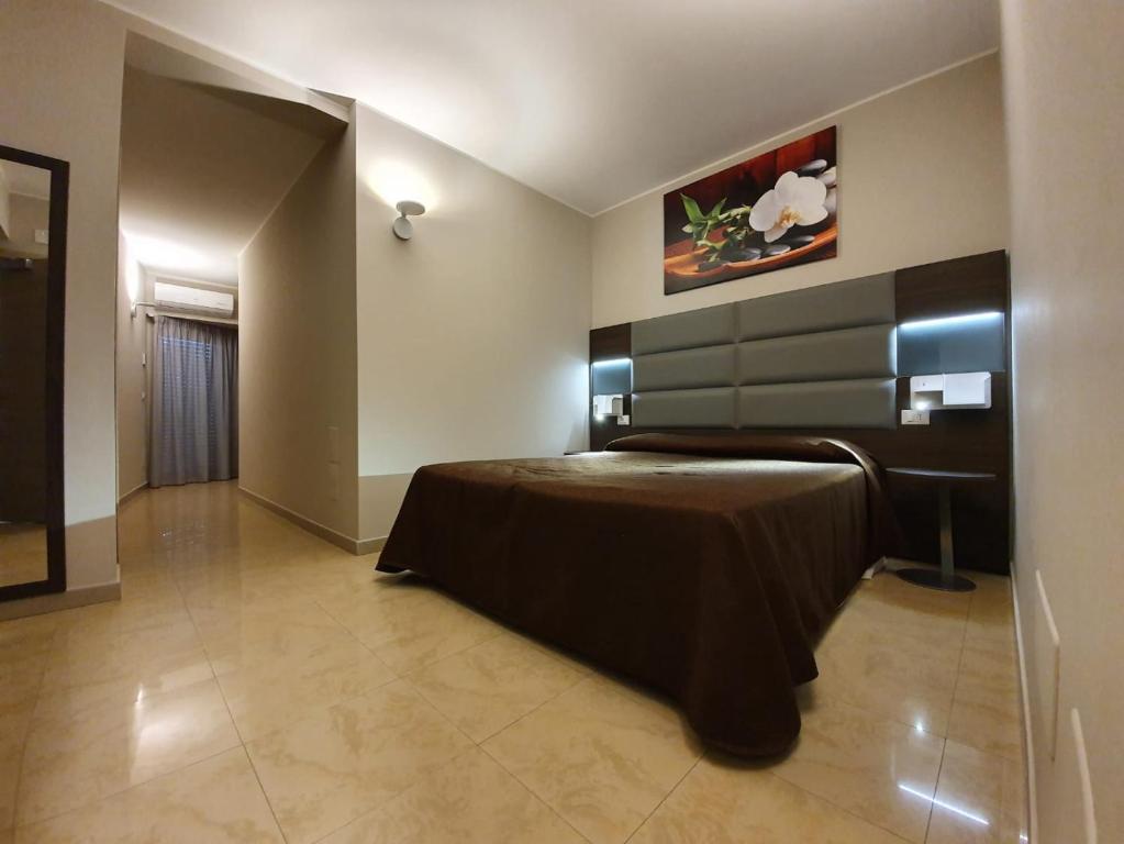 比亚恩卡维拉Hotel Casale dei Greci的卧室配有一张床,墙上挂有绘画作品