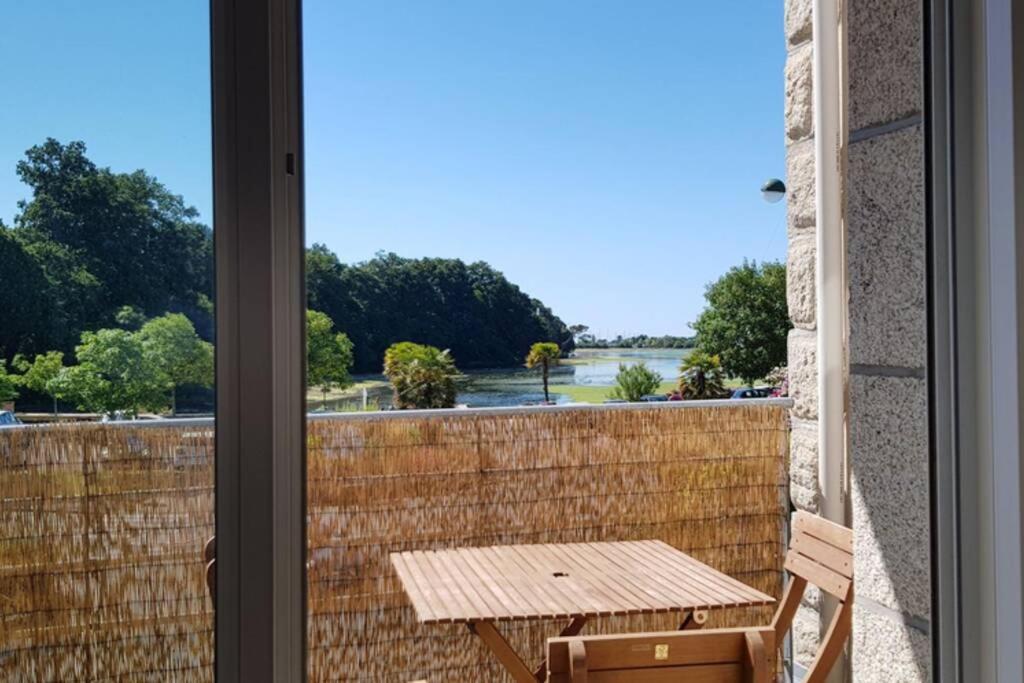 拉福雷富埃南Bel appartement la Forêt-Fouesnant vue sur la baie的阳台配有桌子,享有水景