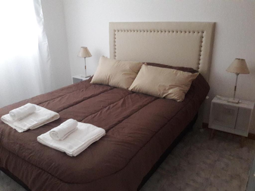 布兰卡港CENTRO NORTE I con cochera incluida的一间卧室配有一张床,上面有两条毛巾