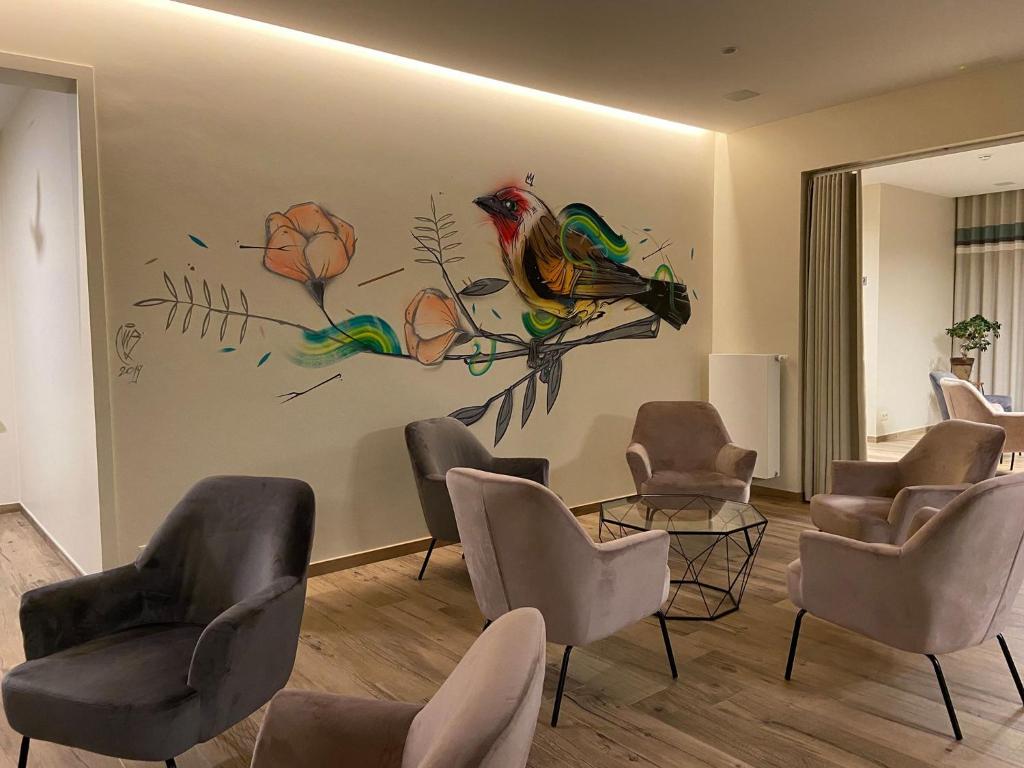 弗朗科尔尚堡萨特酒店的一间设有椅子和墙上涂有鸟儿的等候室
