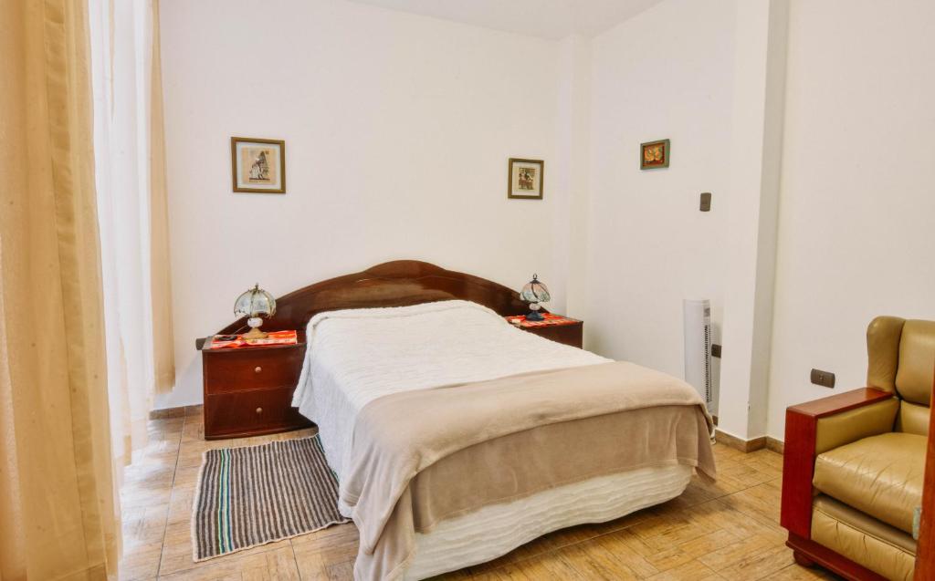 万查科Apartment Acogedor的一间卧室配有一张床和一把椅子